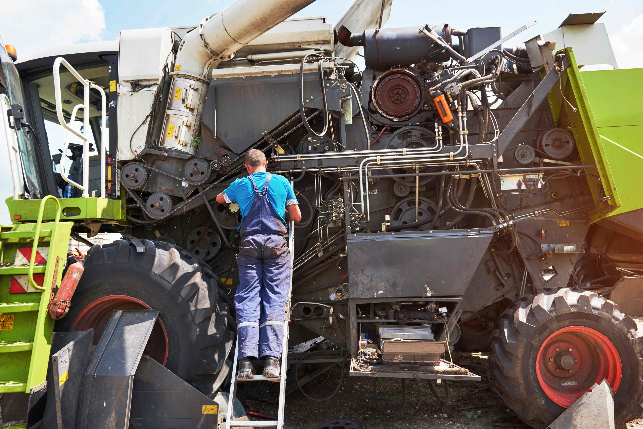 combine machine service mechanic repairing motor outdoors (1)